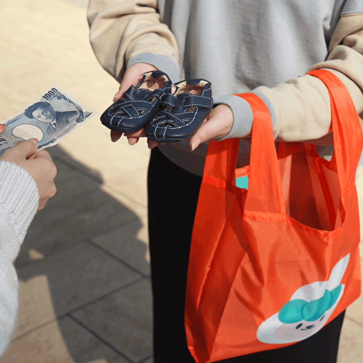 キャロットのオレンジ色のエコバッグで商品を受け渡しする様子